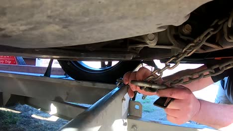 quitar las cadenas de la parte inferior de un coche después del transporte en un remolque