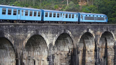 an aging passenger train passes over nine arches bridge near ella in sri lanka