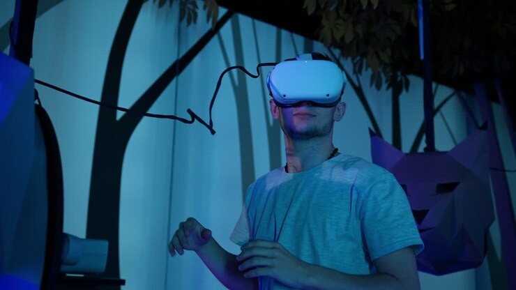 Giovane uomo con un visore VR, una simulazione di trovarsi nel bosco, inquadratura dal basso.