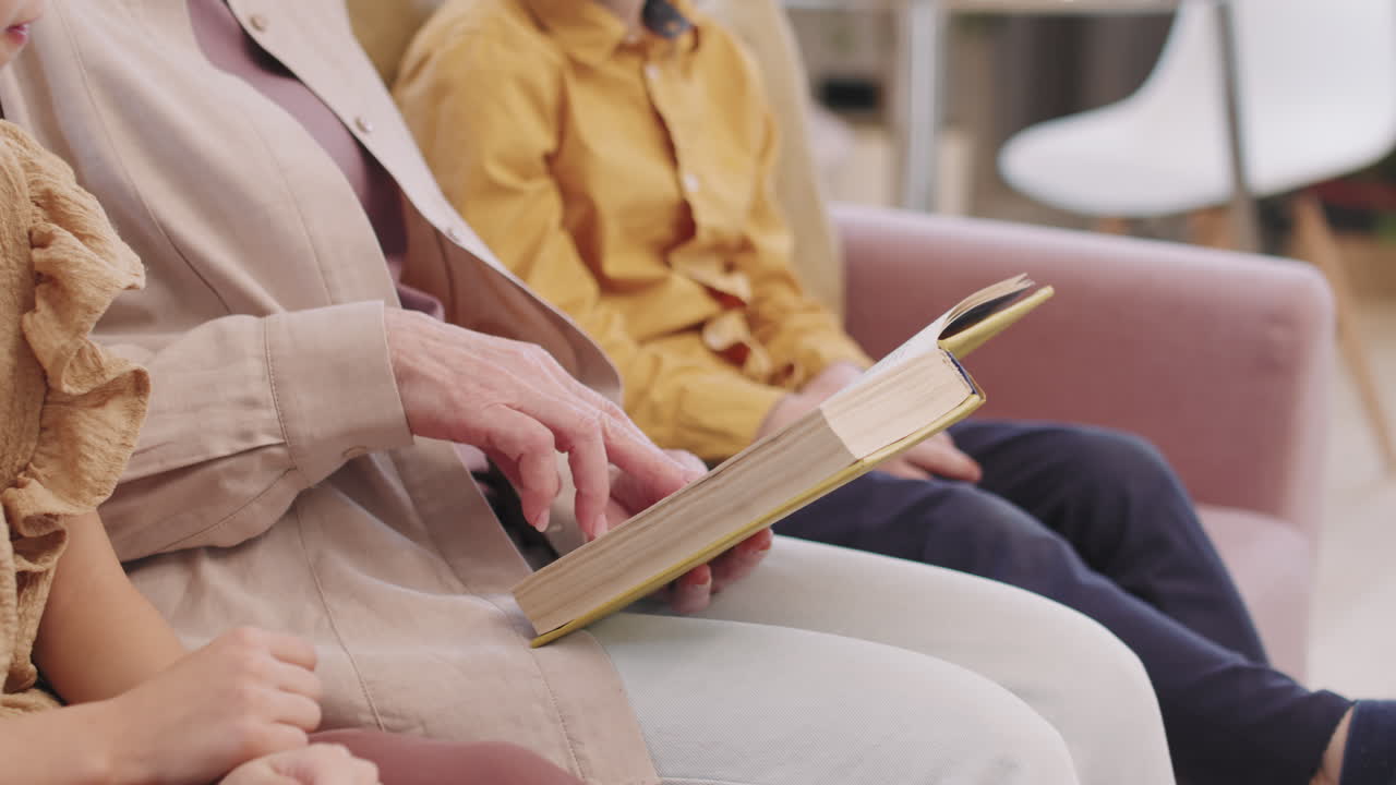 Woman reading book with children