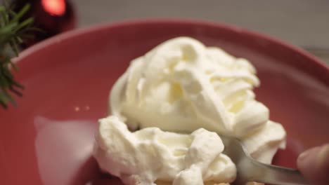 fork and whipped cream topping over mince pie at christmas