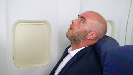 A-business-man-suffering-with-anxiety-on-a-passenger-plane-airliner-airplane