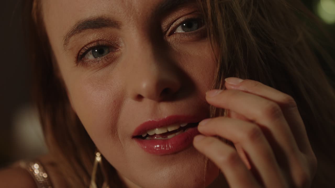 красивый портрет заманчивой женщины, чувственно играющей со своими волосами, глядя на камеру в замедленном движении