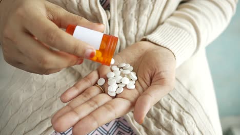 woman pouring pills from a container into her hand