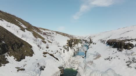 snowy landscape of studlagil canyon and river in iceland, aerial