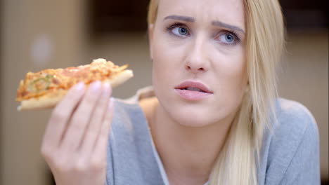 una mujer atractiva comiendo pizza casera.