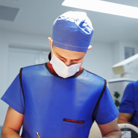 medical specialist in clinic looking down. doctor in medical uniform and mask in the operating room. healthcare concept.