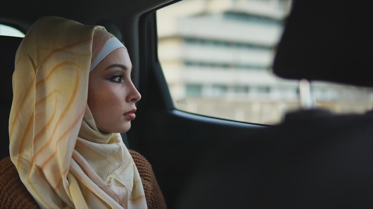 Woman in Hijab Looking Out Car Window