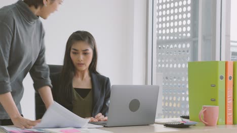 joven mujer de negocios asiática recibiendo una reprensión de su jefa en la oficina