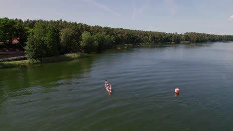 Barco-Dragón-Nada-En-Un-Lago,-Disparo-De-Drones