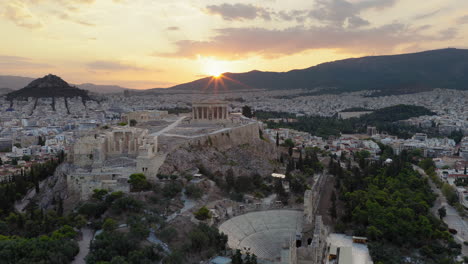 Odeon of Herodes Atticus, Parthenon and Acropolis at sunrise in Athens, Greece, golden flare, drone descends establish