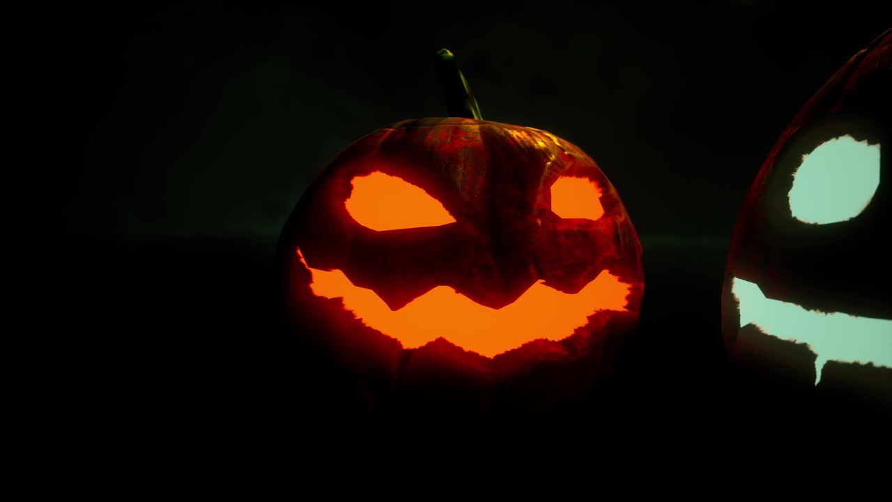 Primo piano di una spaventosa zucca di Halloween arancione e luminosa nell'oscurità.