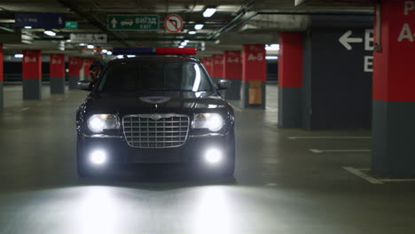 policemen riding in patrol car on underground parking. cops chasing criminal