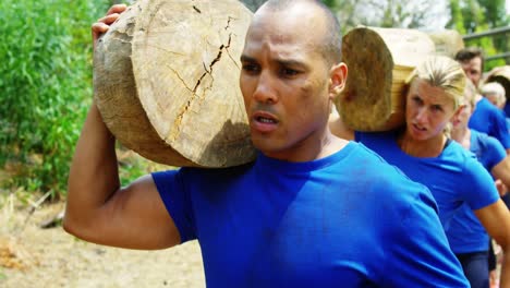 fit people carrying tree log in boot camp 4k