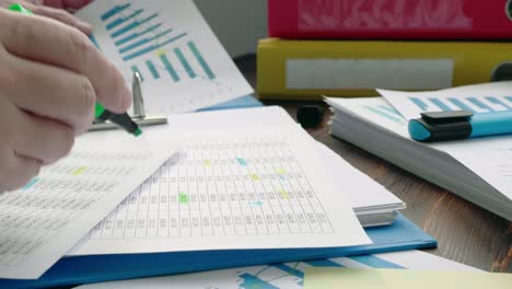 the auditor checks the financial statements. close-up of a hand with a highlighter highlighting the data.