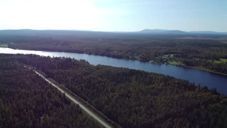 Aerial-drone-shot-of-road-along-river-with-forest-in-Iceland