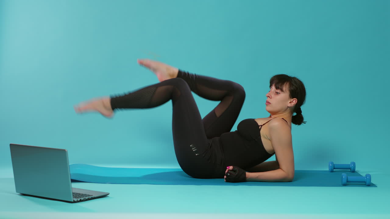 Active person doing bicycle exercise to train legs muscles in studio