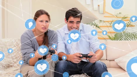 animation of network of connections with icons over caucasian couple playing video games