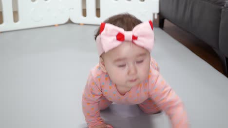 adorable baby girl crawling inside a baby playpen - high angle, close up