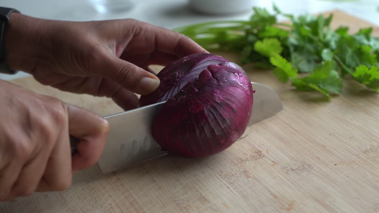 Close up shot of cutting red onion special ingredients to cook a meal two cans of beans rice plantain avocado red onion and cilantro