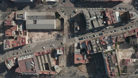 Overhead-view-of-urban-borough.-Cars-parked-along-streets-surrounded-by-various-town-development.-Barcelona,-Spain