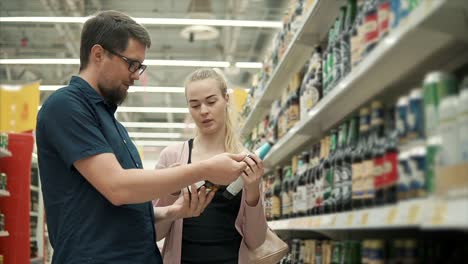 pareja comprando cerveza en una tienda de comestibles