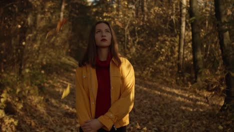 woman walking in forrest and holding fallen leaf