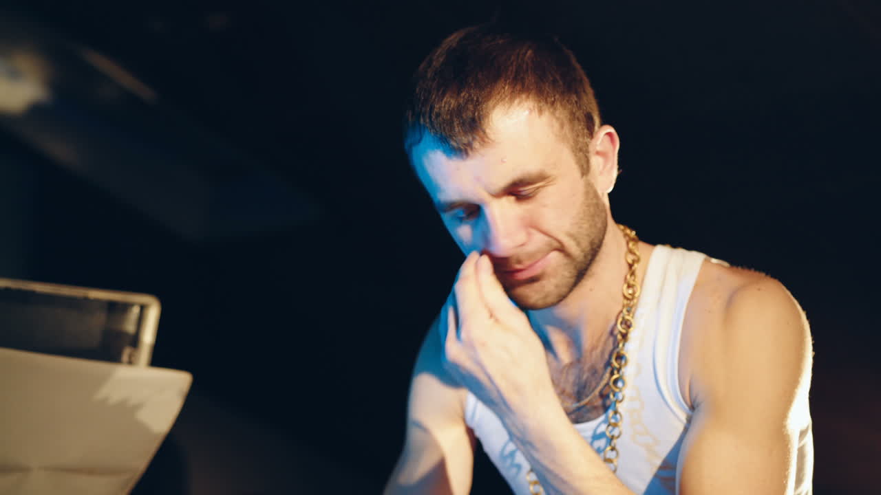 Young man sniffing cocaine on a mirror with a roll of banknotes. Abuse of drugs. Criminal business