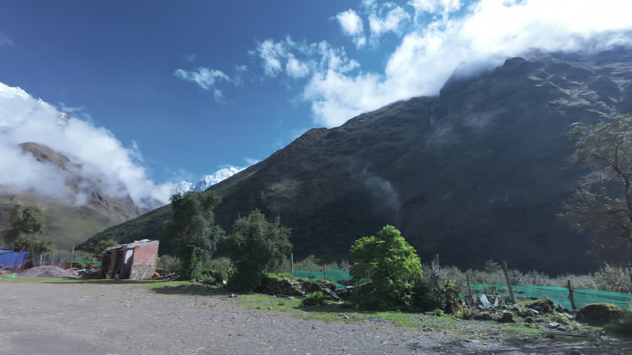 Hikers walking mountain trail toward Humantay peak and turquoise lake