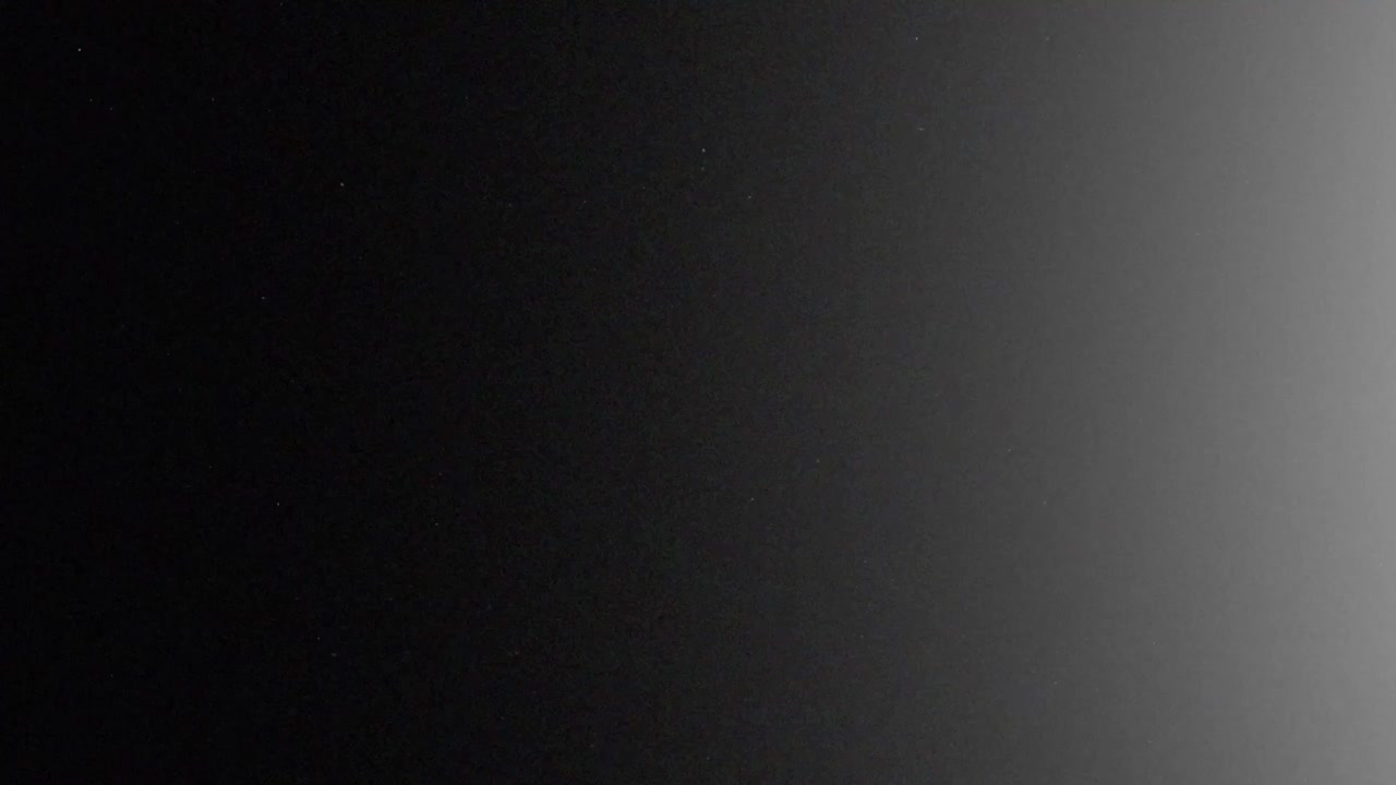 Flash di bruciatura di pellicola analogica in bianco e nero con leggero bagliore di esposizione e sottili granelli di polvere, overlay in loop continuo