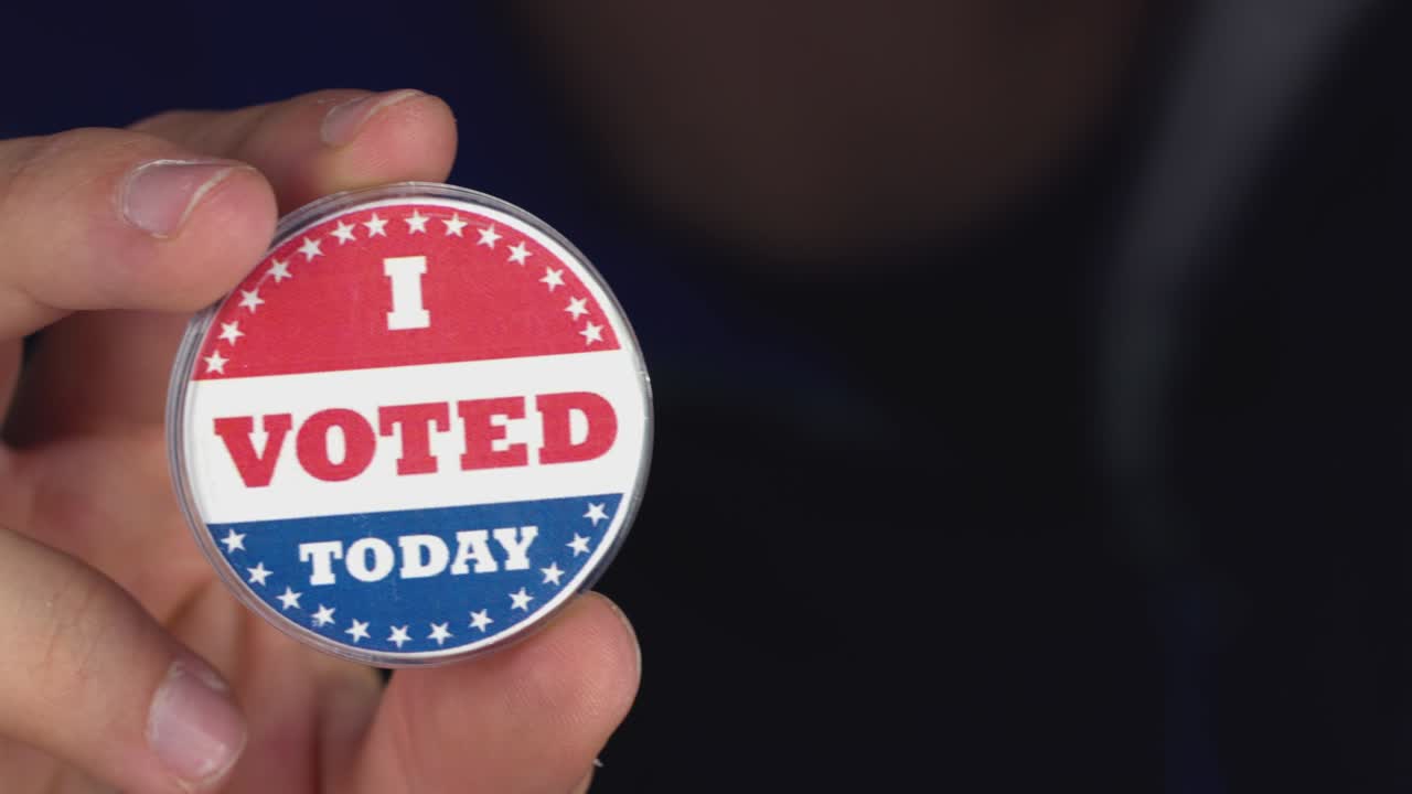 4k 해상도 클로즈업 영상: '나는 오늘 투표했다' 버튼을 들고 있는 손