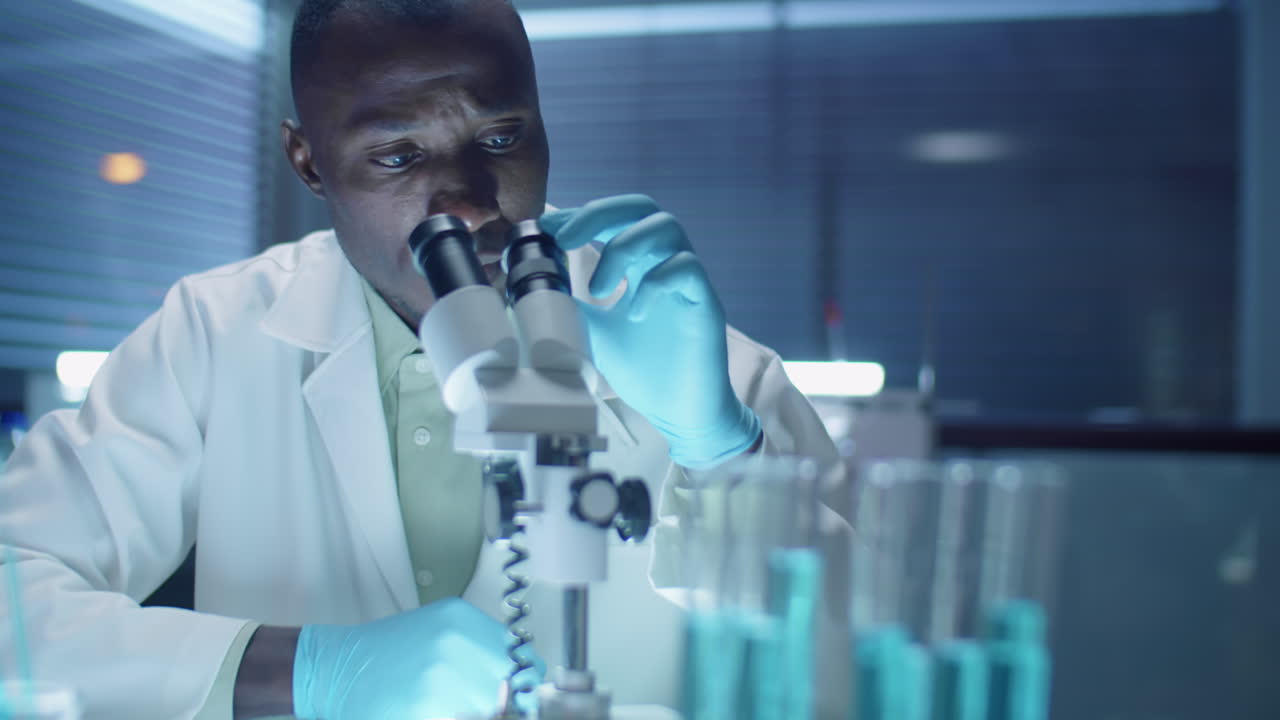 African American Scientist Using Microscope in Laboratory