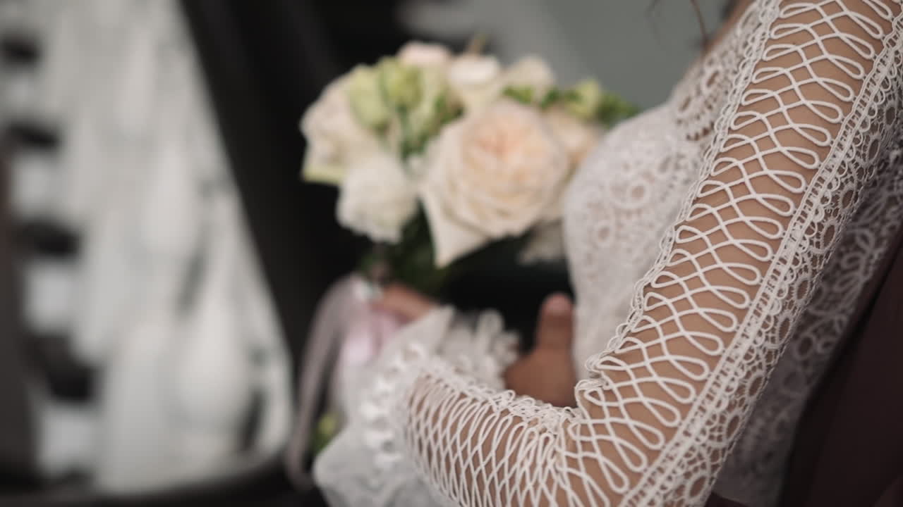 Noivo abraça a amada noiva em vestido vintage segurando o buquê
