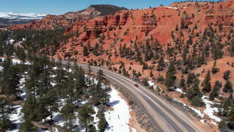 Tracking-Drohnenaufnahme-Eines-Roten-Geländewagens,-Der-Sich-An-Einem-Sonnigen-Wintertag-Auf-Einer-Malerischen-Route-Durch-Arizona-Bewegt