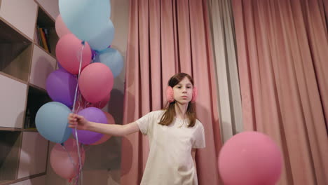 girl playing with balloons at a birthday party