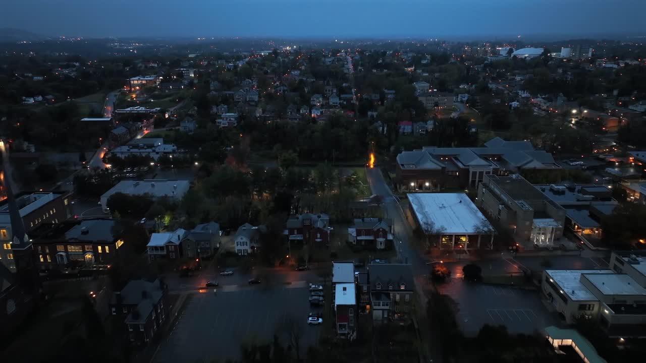 Aerial flight over housing area and neighborhood of american town at night. Rainy day in autumn season. Lighting streets and houses with clouds at sky. Wide shot. Lynchburg, Virginia, USA.