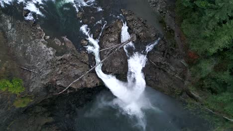 top down aerial of snoqualmie falls and the river that feeds the dam