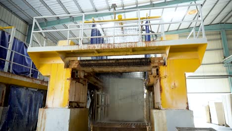 large marble cutting machine slicing marble blocks in a factory. water cools the blade during marble cutting. smooth process showing marble processing and industrial machinery in action