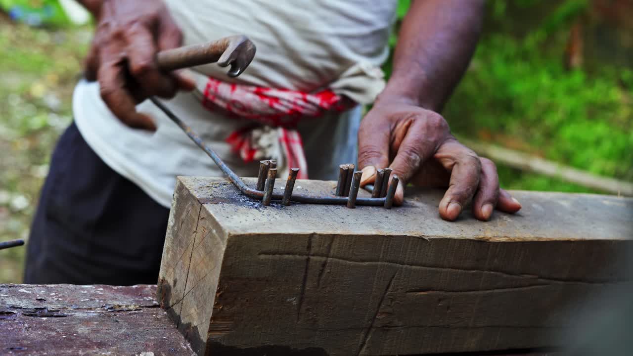 carpintero indio que trabaja doblando metal, hierro y acero utilizando herramientas tradicionales a la antigua