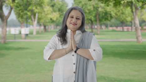 happy indian mother doing namaste and greeting in park