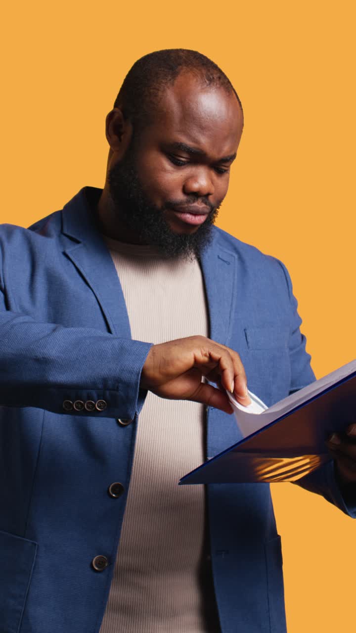Confused African American Man Reviewing Documents in Folder