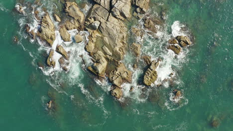 top down view of sea waves and fantastic rocky coast, praia armacao, florianopolis, santa catarina, brazil