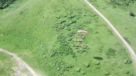 paragliding in the mountains. green fields, hills