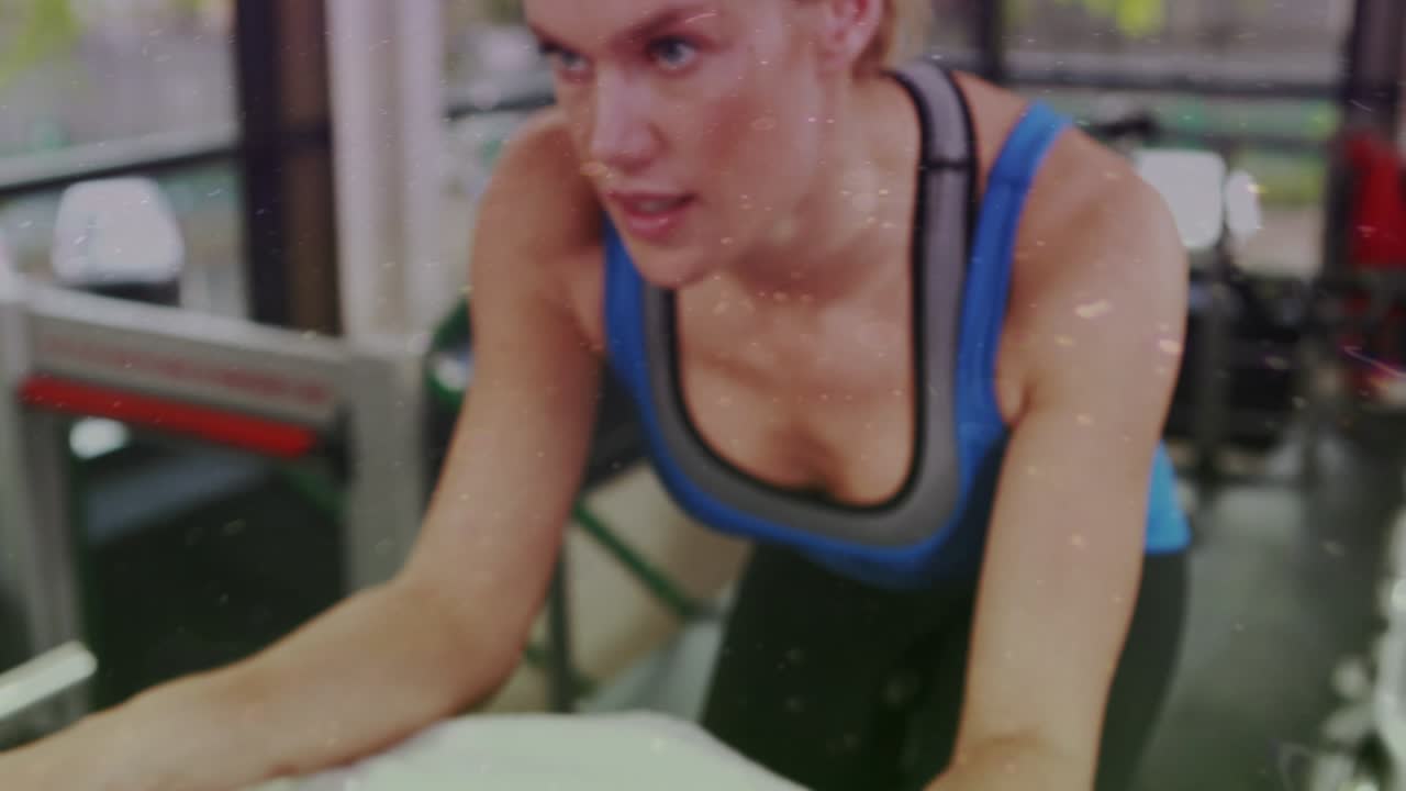 Woman leaning on gym bench, adjusting towel to steady bottle as camera shifting and graphics fading