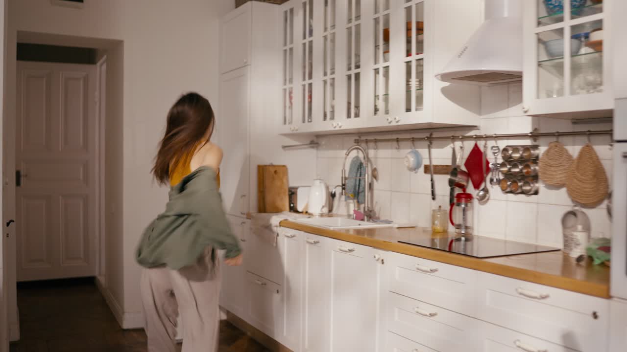 Una donna si toglie il cappotto nel suo appartamento