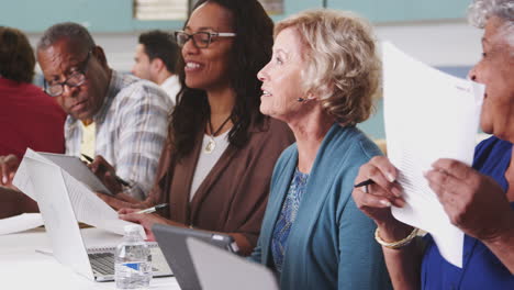 group of retired seniors attending it class in community centre