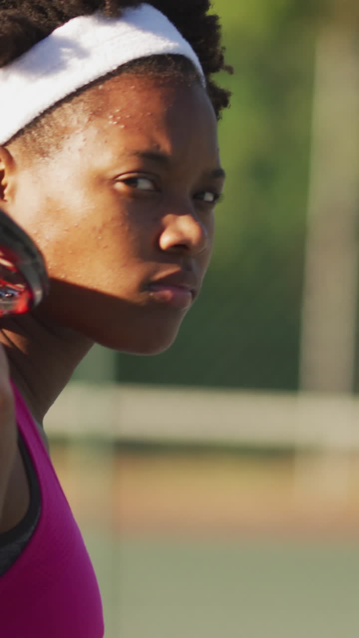 video de una tenista afroamericana sosteniendo una raqueta y mirando a la cámara