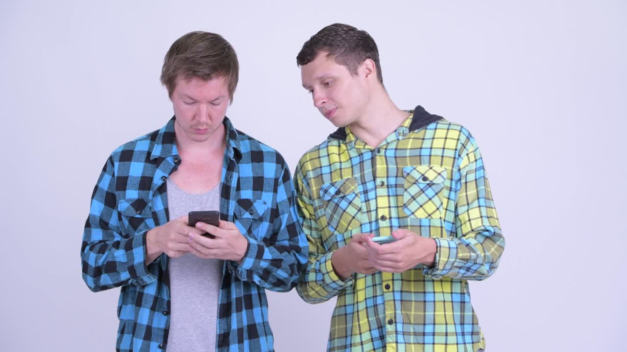 dos jóvenes felices y guapos como amigos con el teléfono