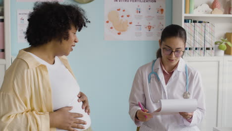 pregnant woman consulting with her doctor