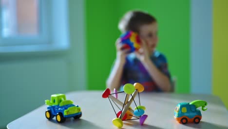 toys on table. bright toys on blur background of preschooler boy. happy childhood. little boy having fun with toys.